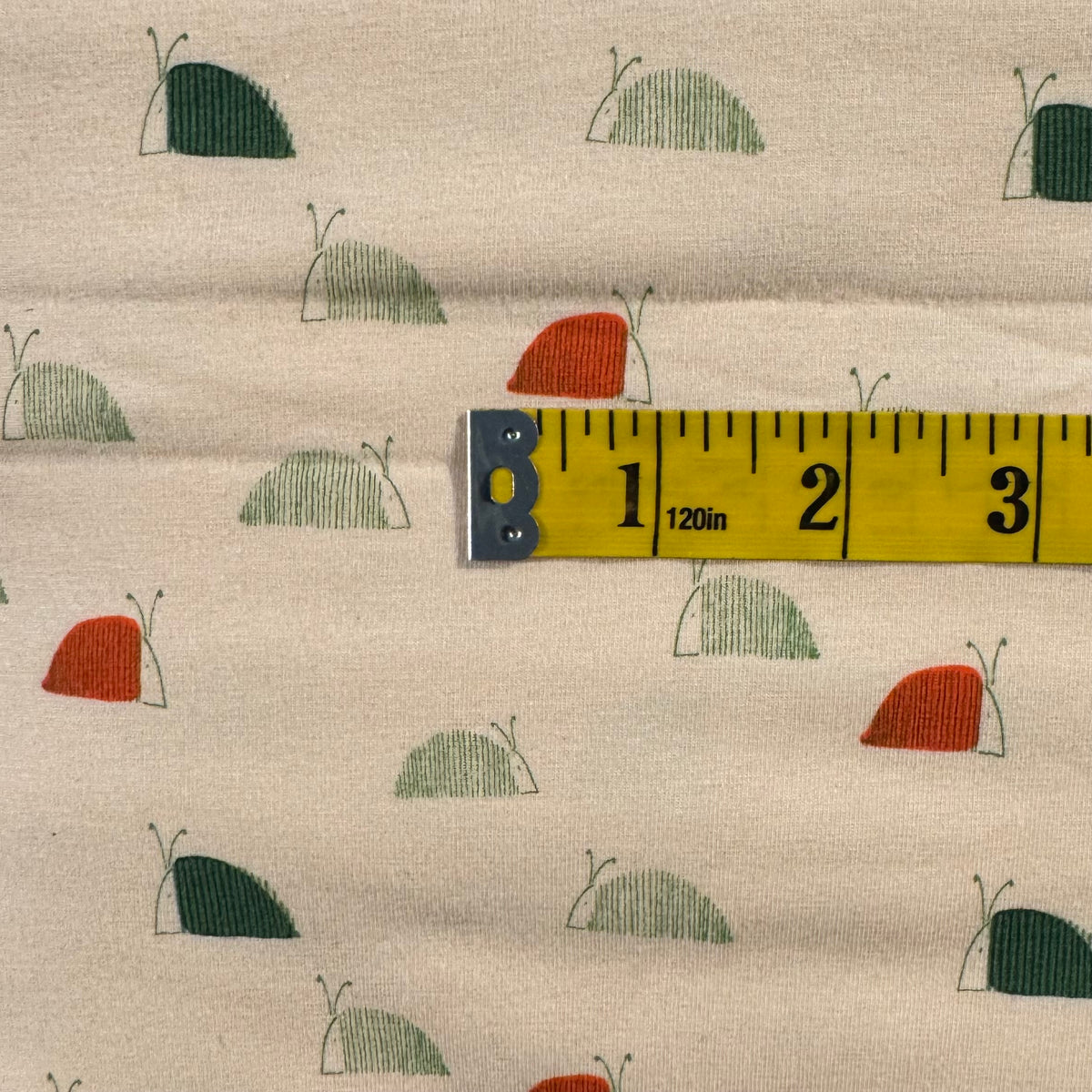 Cream With Red & Green Snails Stretch Jersey: 4 yds